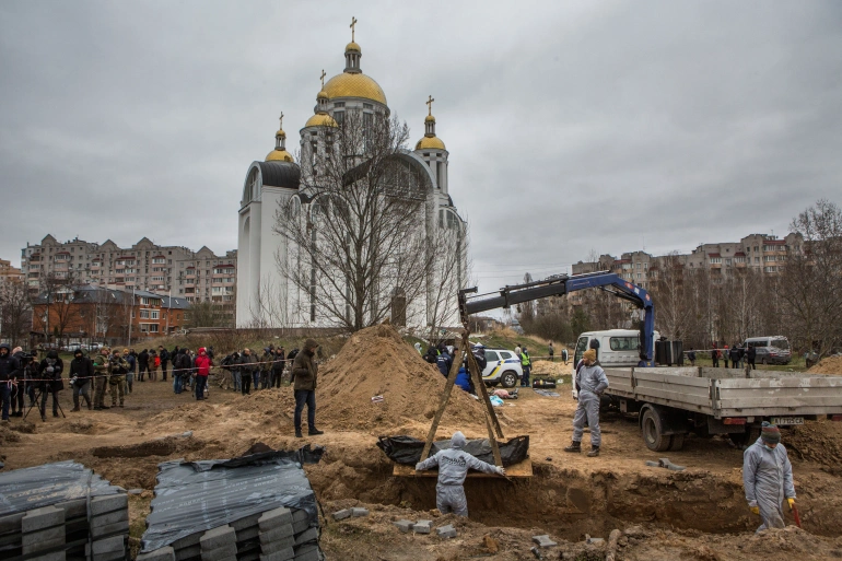 Forensic technicians exhume the bodies of civilians who Ukrainian officials say were killed during Russia's invasion and then buried in a mass grave in the town of Bucha, outside Kyiv [File: Volodymyr Petrov/Reuters]