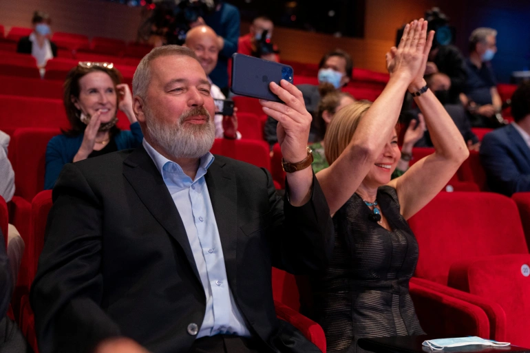 Dmitry Muratov watched and filmed the bidding for his 2021 Nobel Peace Prize medal with the audience breaking into cheers and applause [David ‘Dee’ Delgado/Reuters]